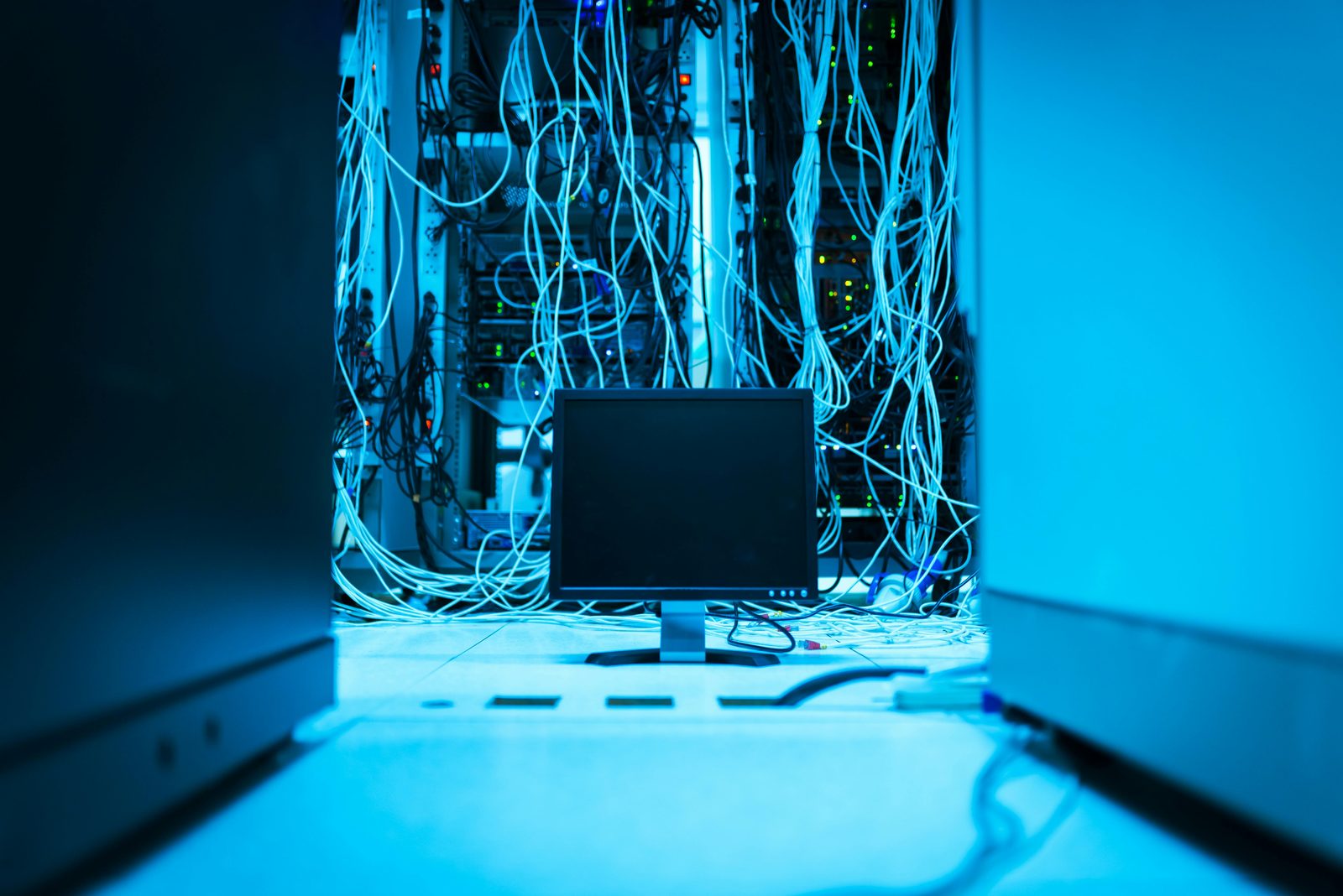 A tangle of cables in a server room — the disjointed systems we replace.